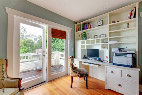 Foto Home office with green walls and white shelves