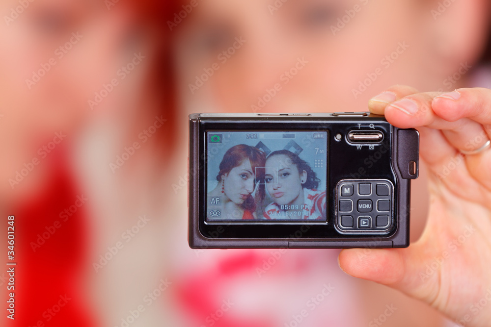 Two funny girlfriends on photo camera screen