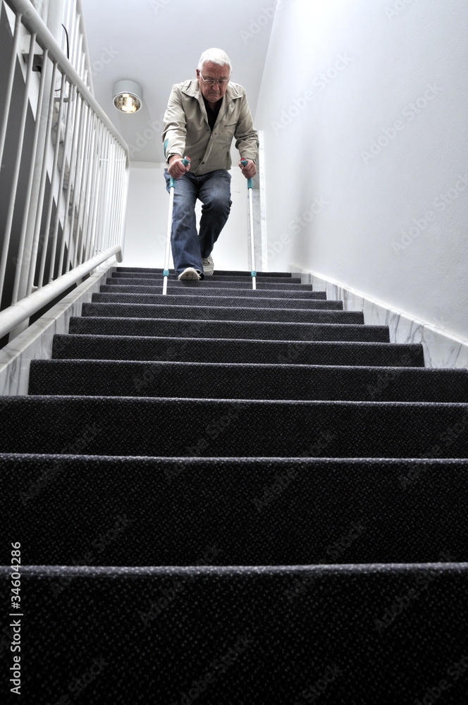 Senior mit Krücken auf einer Treppe - obrazy, fototapety, plakaty 