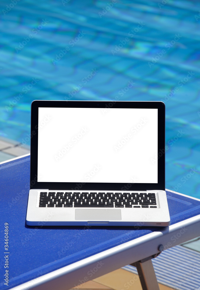 Laptop by swimming pool and tropical vacation resort Laptop by swimming pool and tropical vacation resort