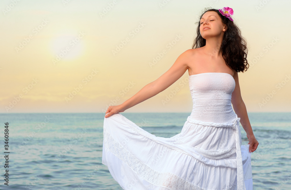 The woman in a white sundress on seacoast The woman in a white sundress on seacoast
