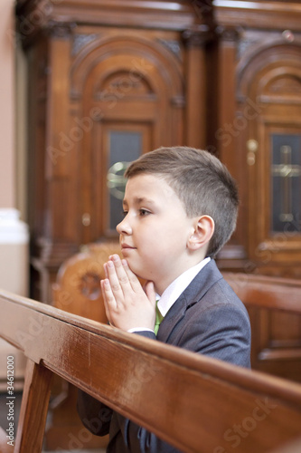 Boy kneeling and praying in the church.