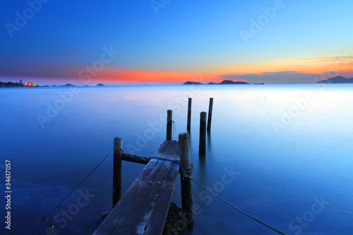 Sunset at dusk along a wooden pier, high saturation image.