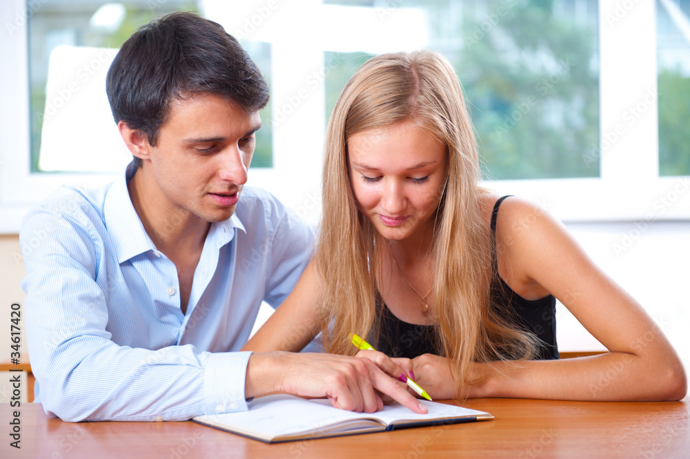 Portrait of teacher helping young student with her studies in co Portrait of teacher helping young student with her studies in co