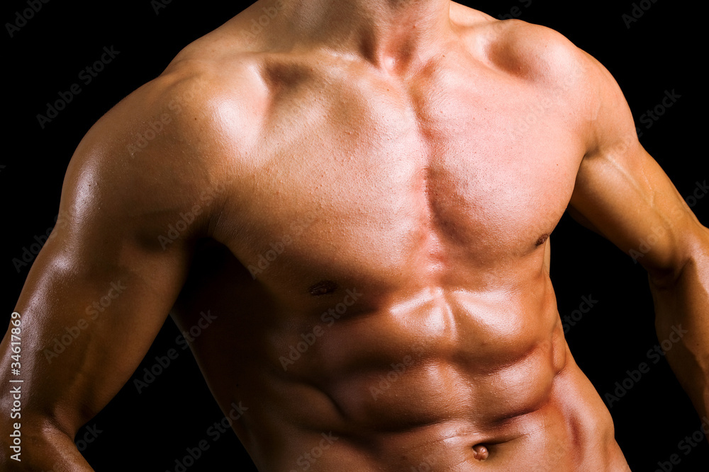 Beautiful naked male torso against black background