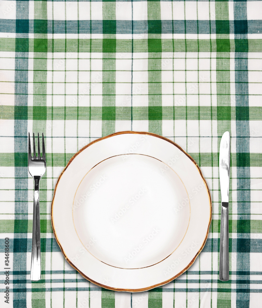 white plate on green checkered tablecloth with knife and fork white plate on green checkered tablecloth with knife and fork