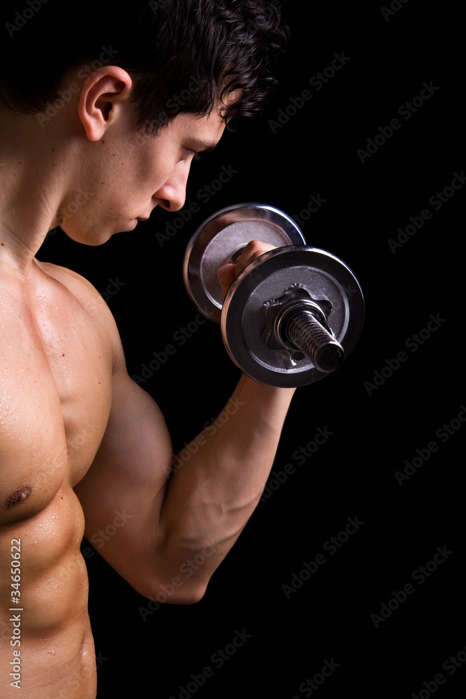 Muscular young man lifting dumbbells on black background. Muscular young man lifting dumbbells on black background.