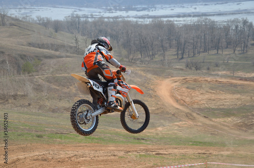 Motocross rider on a motorbike jumps from big mountain