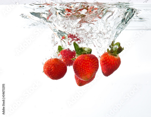 Strawberries dropped into water splash