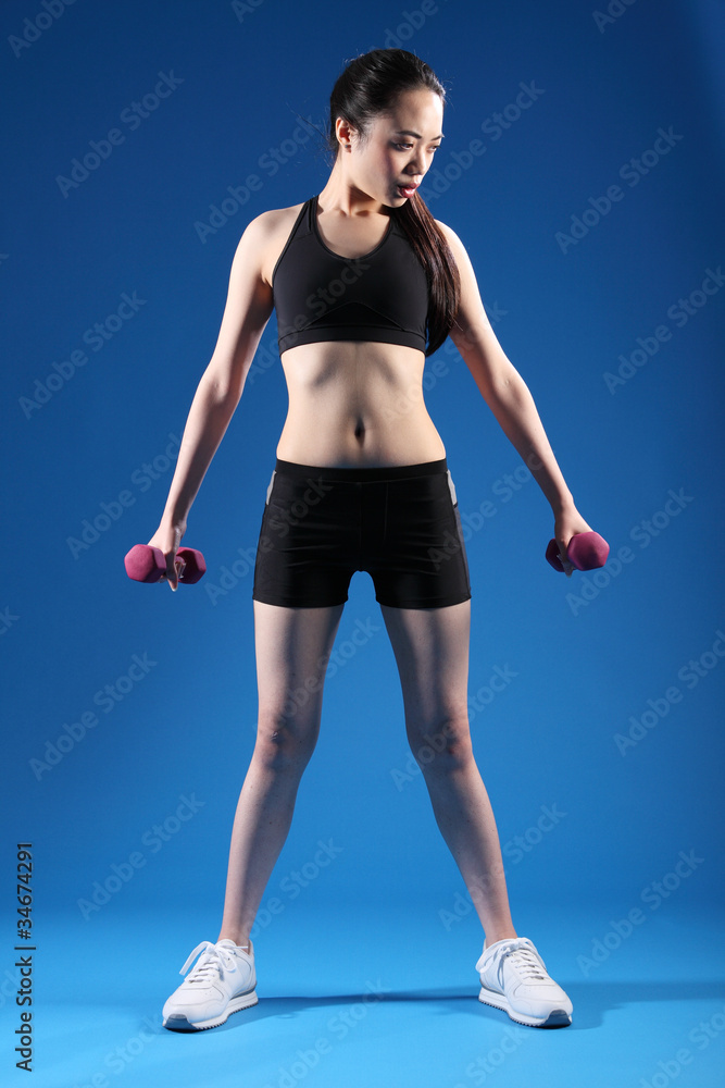 Beautiful slim asian girl using exercise weights