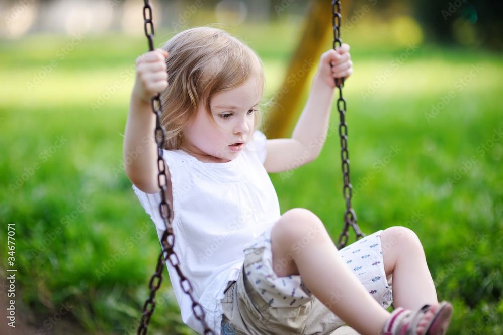 Adorable little girl having fun on a swing Adorable little girl having fun on a swing