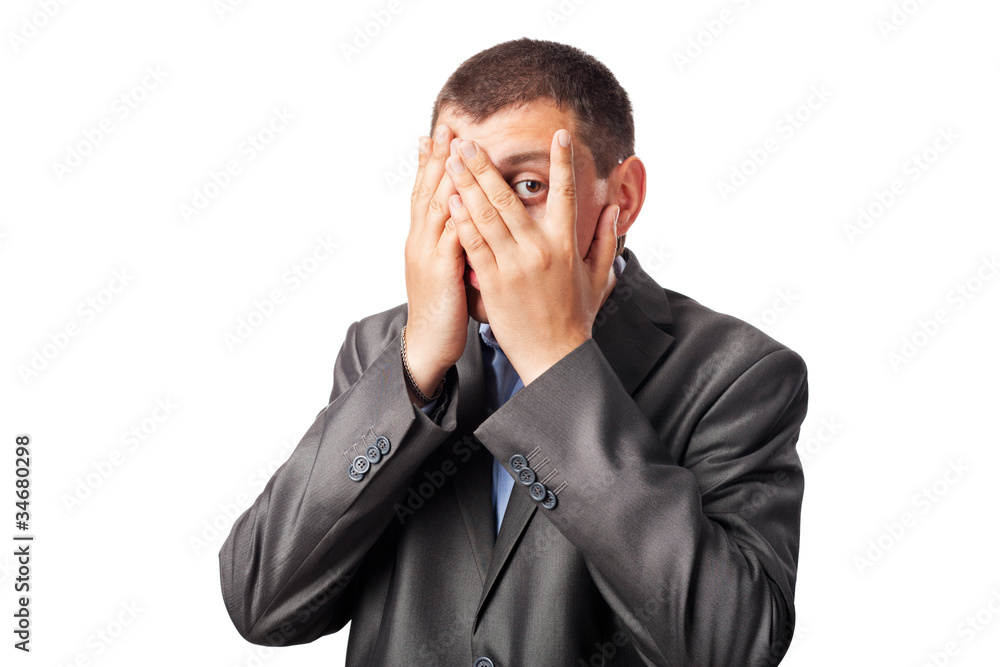 sad businessman covering face by hands and looking through finge sad businessman covering face by hands and looking through finge
