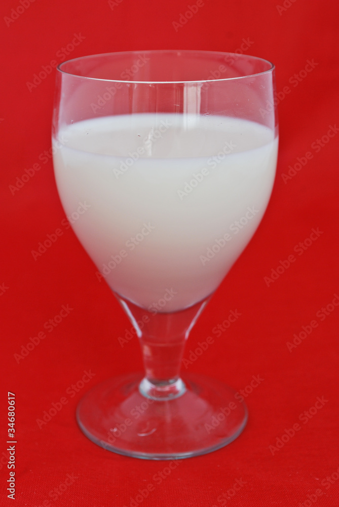 Glass of fresh milk isolated on red background Glass of fresh milk isolated on red background
