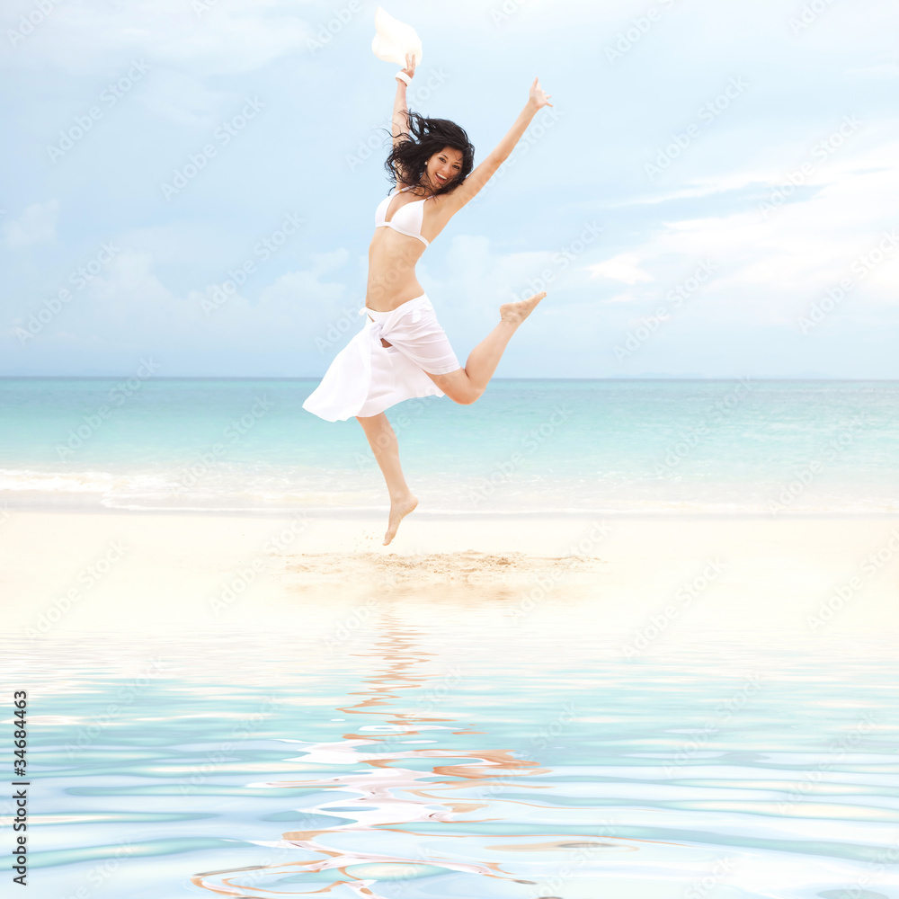 happy young woman jumping on the beach of sea happy young woman jumping on the beach of sea