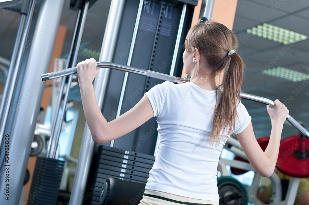 Powerful casual woman lifting weights in gym Powerful casual woman lifting weights in gym