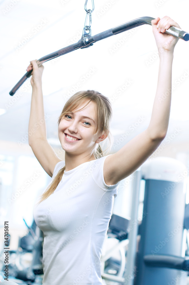 Powerful casual woman lifting weights in gym Powerful casual woman lifting weights in gym