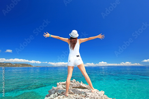 海に向かって大きく手を広げる女性