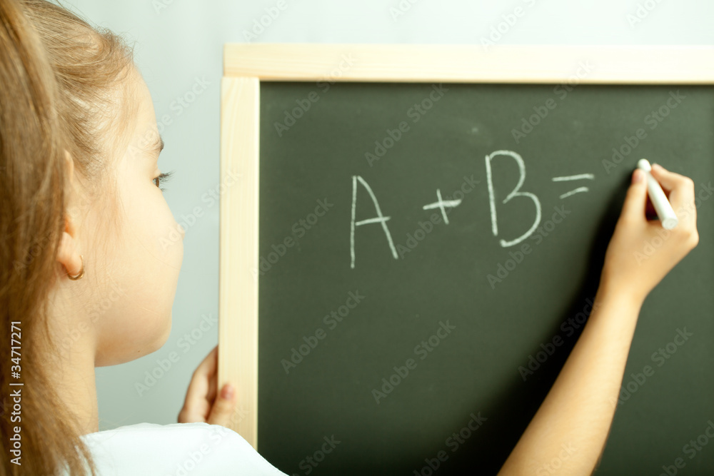 School girl write exercise on the black board School girl write exercise on the black board
