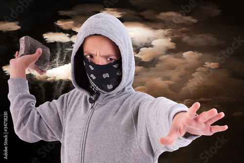 A teen with a rock, in a act of juvenile delinquency