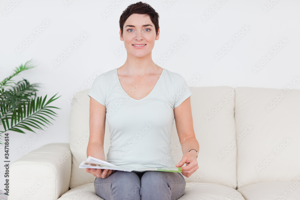 Brunette smiling Woman with a magazine Brunette smiling Woman with a magazine