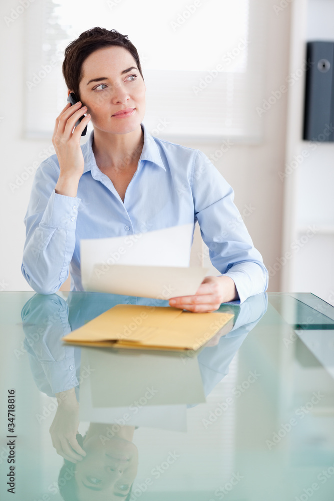 Businesswoman with papers on the phone Businesswoman with papers on the phone