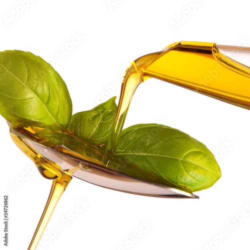 Oliwa z oliwek z bazylią na białym tle photo