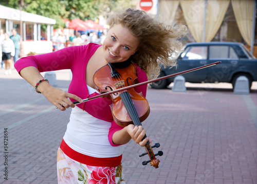 Pretty young woman with violin in the street