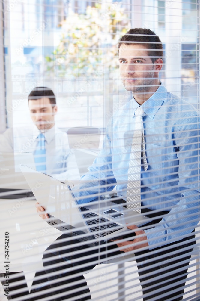 Fototapeta premium Young businessmen working in bright office