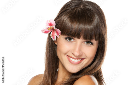 Closeup portrait of young female with flower over ear