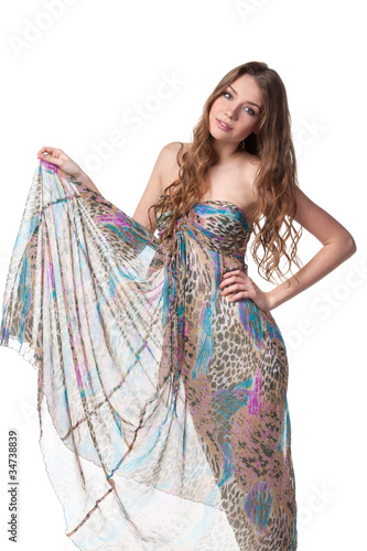Young charming female in chiffon dress lifting her dress hem