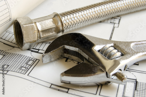 Plumbing tools over house blueprint