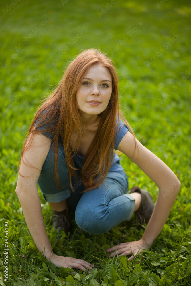 beautiful red-haired girl sitting on grass beautiful red-haired girl sitting on grass