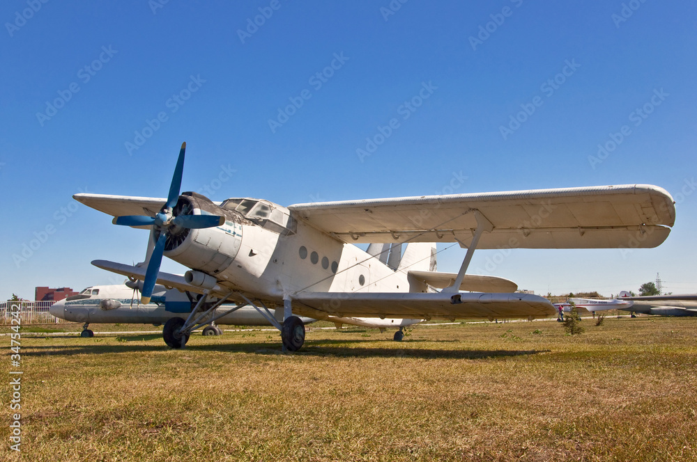 old russian airplane on grass and blue sky background old russian airplane on grass and blue sky background