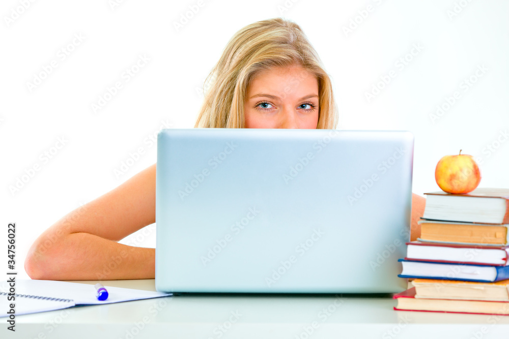 Sitting at table teen girl looking out from laptop Sitting at table teen girl looking out from laptop