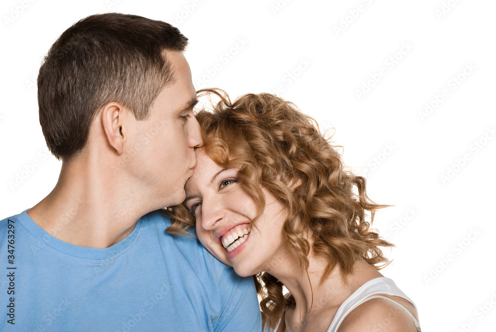 Beautiful young couple kissing against white background Beautiful young couple kissing against white background