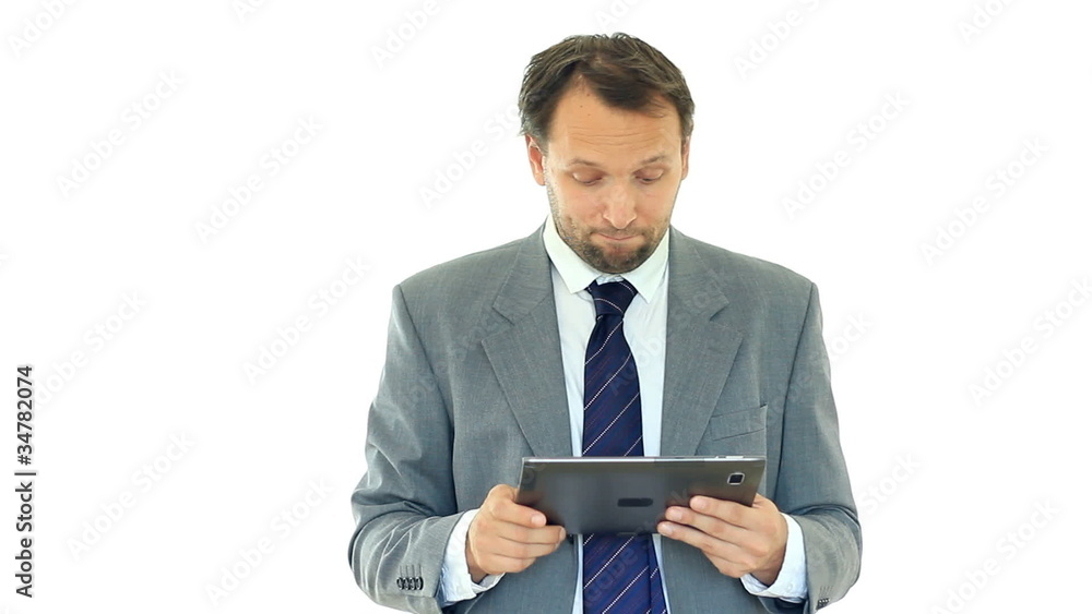 Unhappy businessman looking at bad news on tablet computer Unhappy businessman looking at bad news on tablet computer