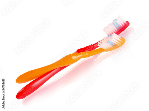 red and orange toothbrushes isolated on white