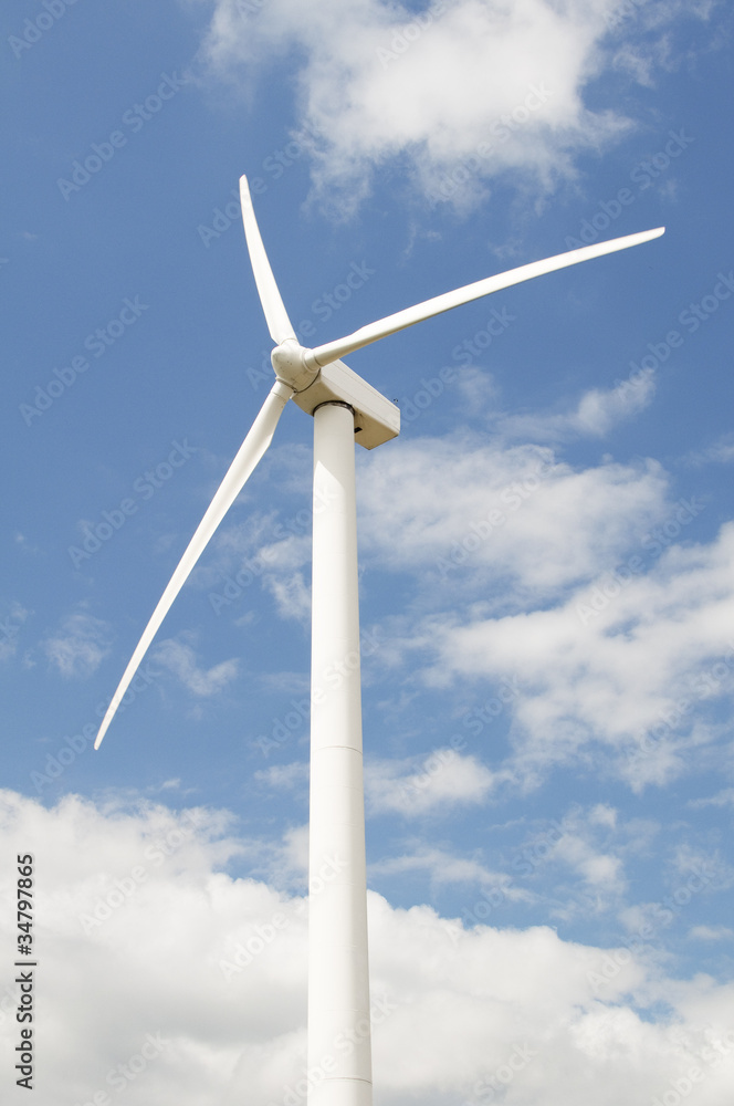Wind turbine against a sky blue background with clouds - obrazy, fototapety, plakaty 