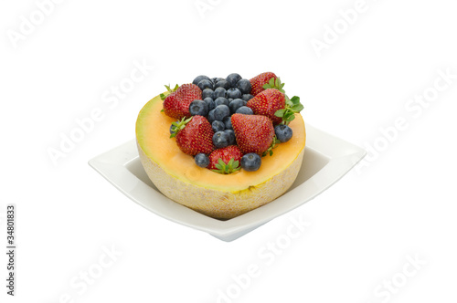 Fruit desert of berries and cantaloupe in white bowl