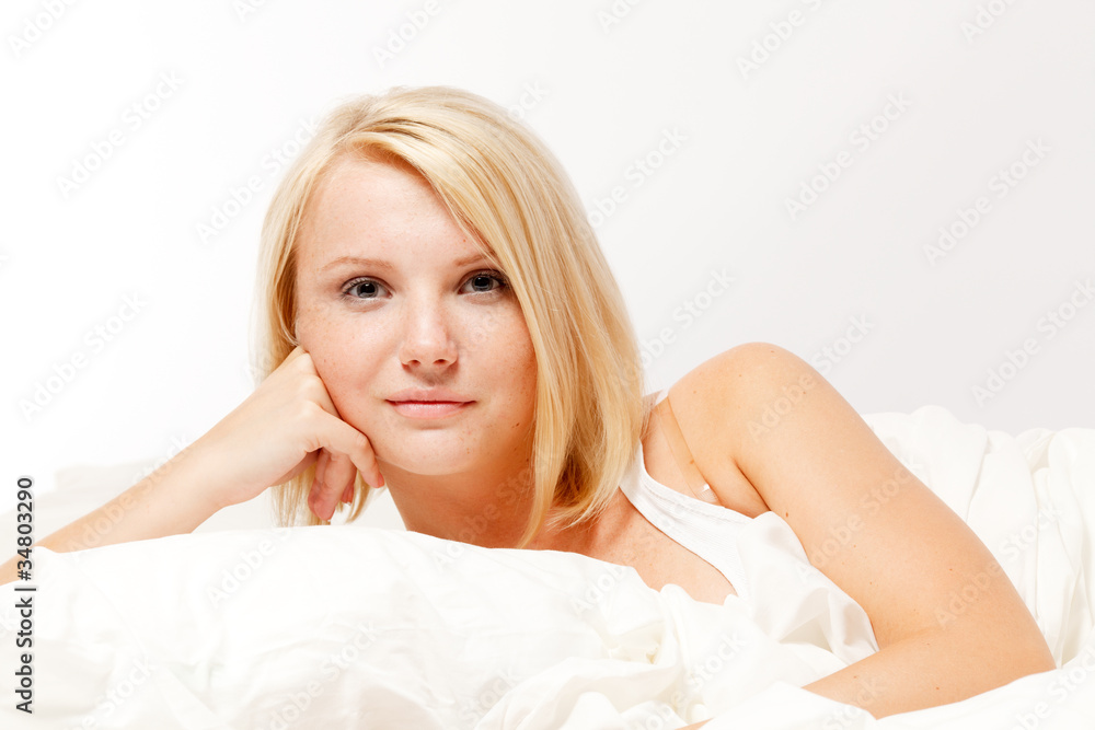 A beautiful smiling young woman lying in bed A beautiful smiling young woman lying in bed