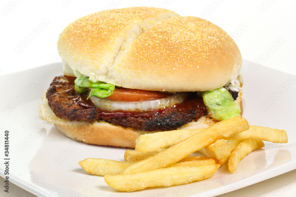 Hamburger with lettuce, tomato, onion and chips on the plate