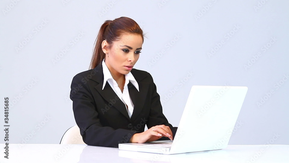Business woman sitting at the desk and using laptop computer Business woman sitting at the desk and using laptop computer