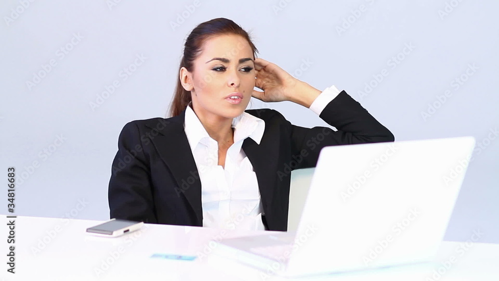 Business woman sitting at the desk and checking her smartphone Business woman sitting at the desk and checking her smartphone