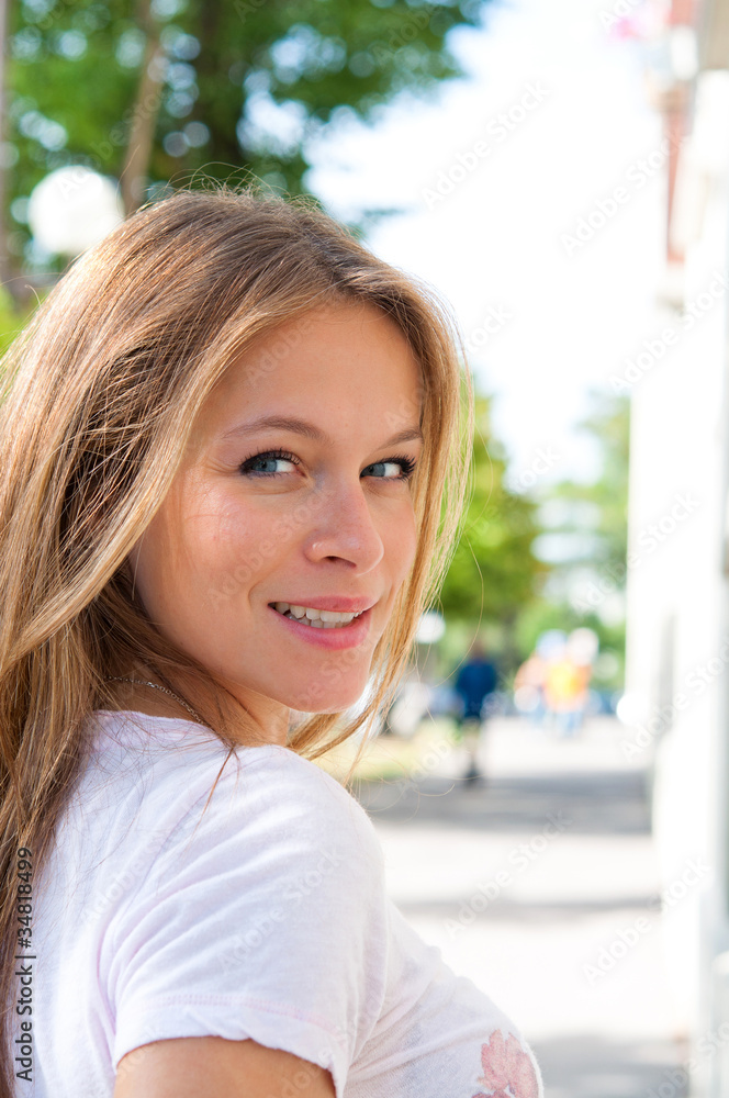 young woman smiling while looking back .