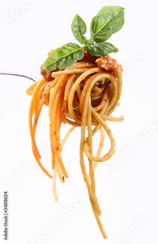 Spaghetti with basil leaves on a fork