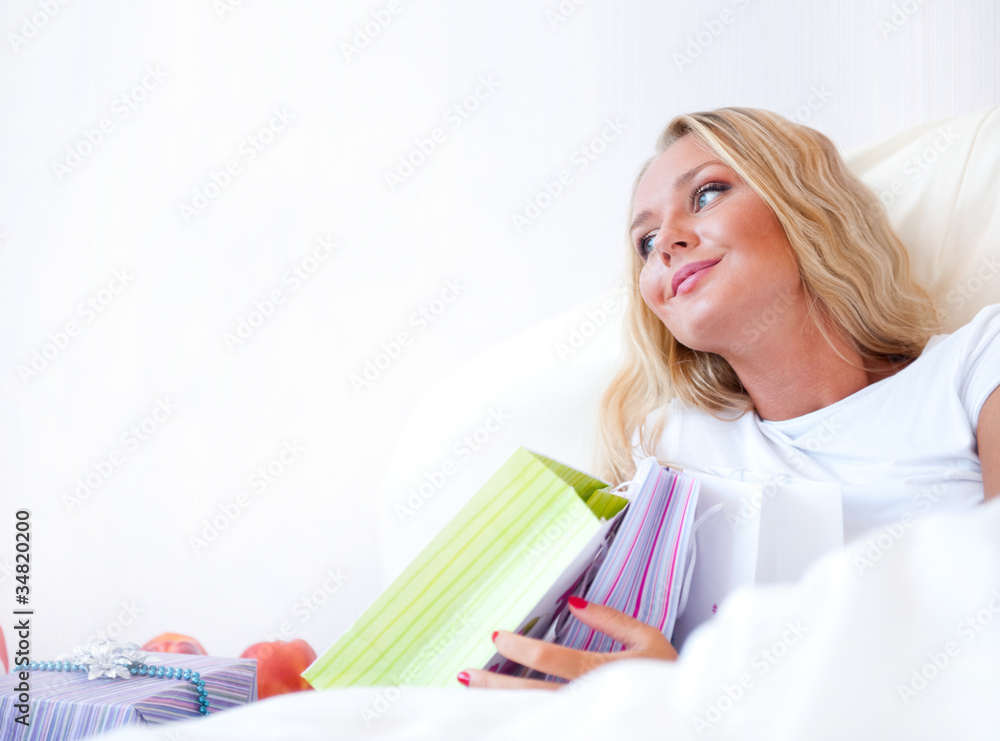 Young happy attractive girl unpack shopping bags in bedroom or h Young happy attractive girl unpack shopping bags in bedroom or h