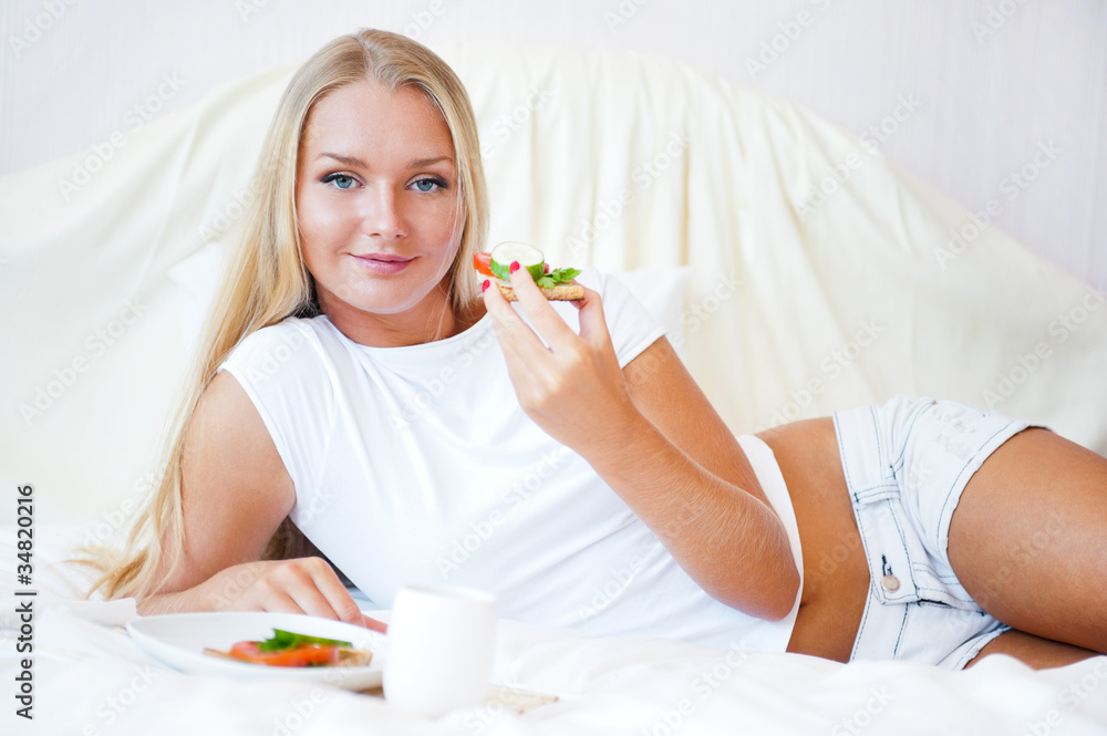 Woman having breakfast in bed. Healthy continental breakfast. Ca