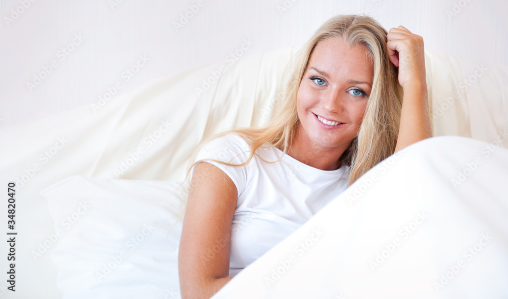 Young blond woman enjoying a sunny morning in bed Young blond woman enjoying a sunny morning in bed