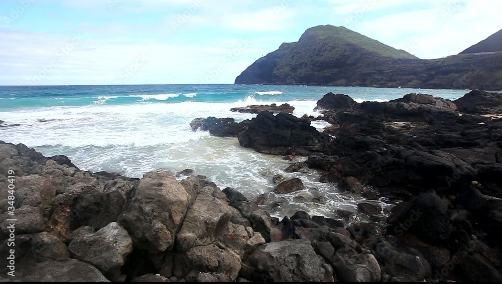 Ocean waves are washing over a rocky shore. Ocean waves are washing over a rocky shore.