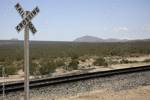 Bahngleise in der Wüste mit Schild Railroad crossing